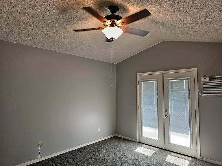 Master bedroom with ceiling fan & french doors.