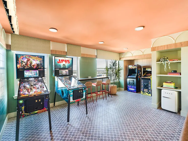 Our Wes Anderson-inspired vintage arcade room features pinball and classic games, offering a playful retreat with skyline views in the heart of Dallas.