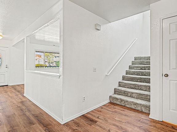 4__ Entry Hallway / Main Level
Entry hallway with wood-style flooring and access to kitchen, living area, dining area, bathroom, primary bedroom, laundry room, and staircase.