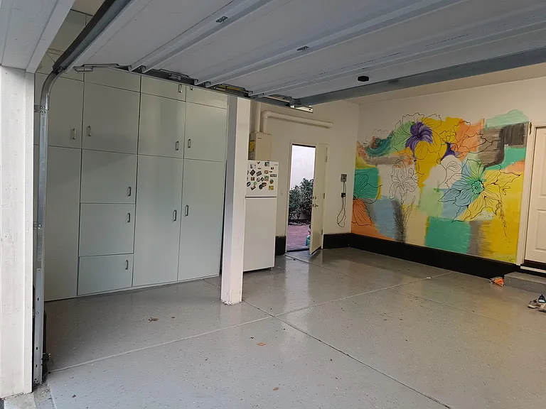 This final photo showcases the beautifully crafted garage cabinets, offering ample storage for your tools and belongings. The backdrop of the designer-painted wall adds a touch of sophistication, making this garage both functional and visually appealing.