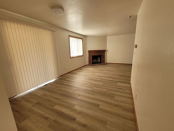 Family/Living room with sliding door to backyard and corner wood burning fireplace.