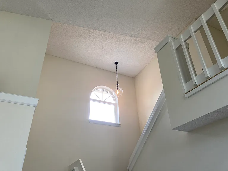 Stairs to upstairs bedrooms and bathroom with tub.