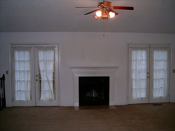 Vaulted ceiling in the living room with fireplace and French Doors to porch.