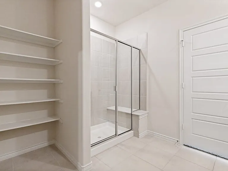 Walk-in shower with clear glass enclosure and integrated bench seating
