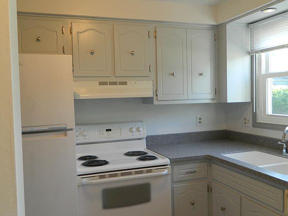 Kitchen with new floor, counter tops, sink, and refrigerator
