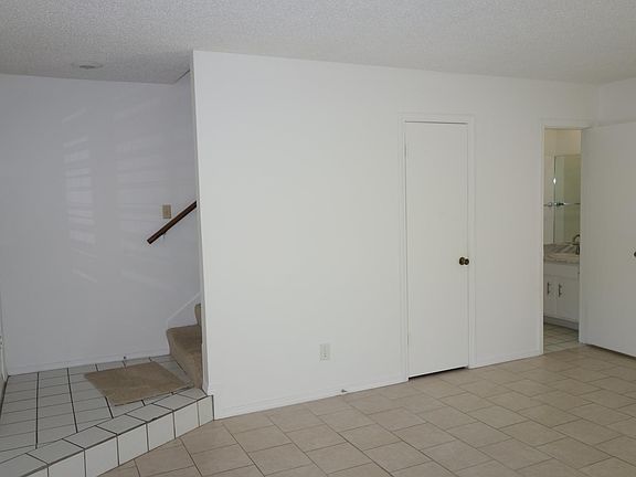 Living room facing South. Entry and stairs on the left. Understairs closet in middle and half bath and coat closet on the right.