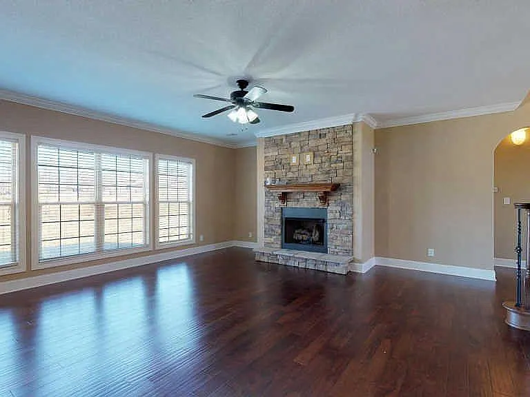 Main level formal sitting living room (2nd fireplace) with abundant windows overlooking the serene fenced back yard.