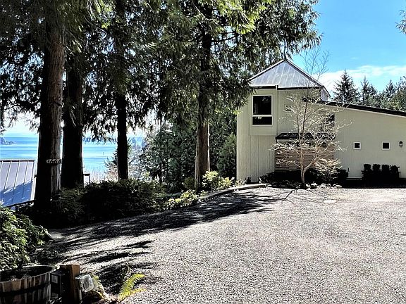 Exterior of cottage and driveway/parking area.