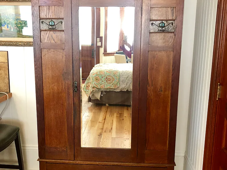 This Art Nouveau antique armoire provides extra options for guests and stores extra bedding in bottom drawer.