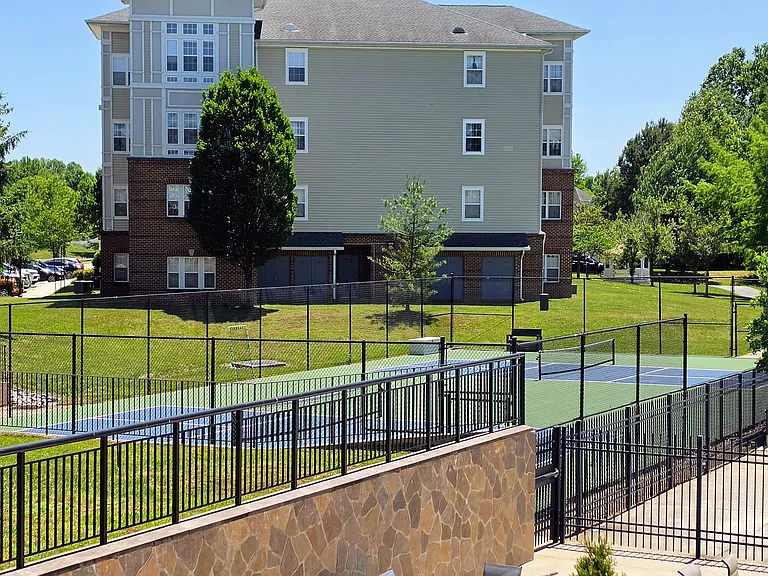 Professional-grade, fenced outdoor tennis and pickleball courts, beautifully maintained for resident recreation.