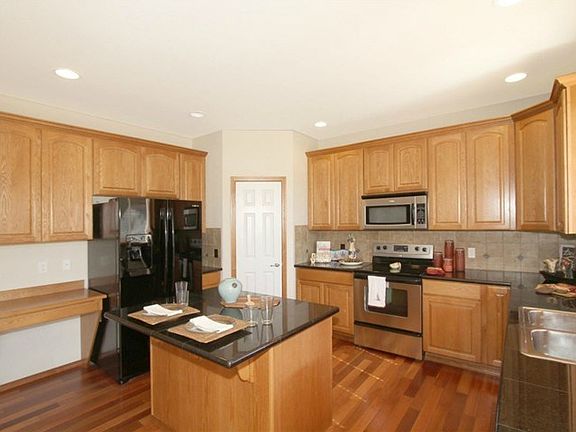 Kitchen has lots of cabinets, huge drawers, desk area, and a pan