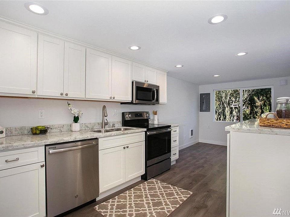 Kitchen with sparkling counters, new cabinets, & SS appliances.