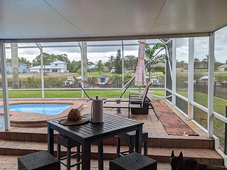 Covered, outdoor dinner table and seating. This is a beautiful setting for sunset dinners. Dog not included.