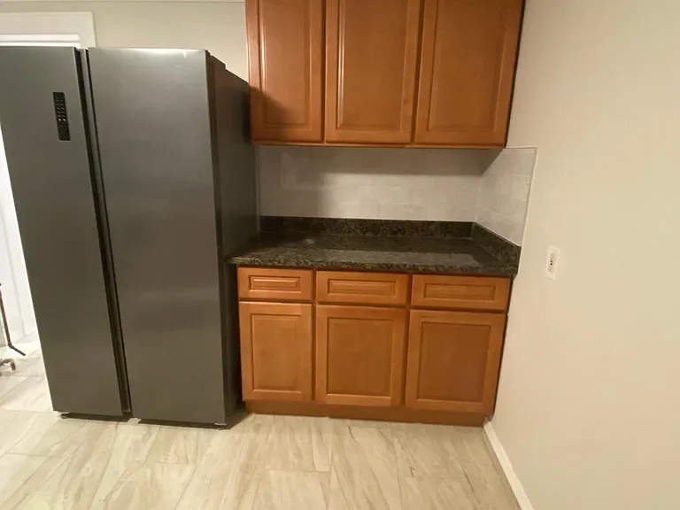 lots of kitchen cabinets, full refrigerator, more granite and backsplash.