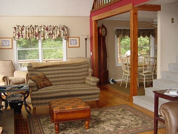 The living room has inlaid hardwood flooring, and a floor to ceiling stone fireplace.