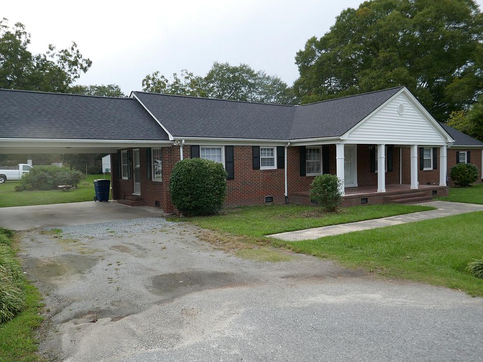Front of house with driveway and carport.