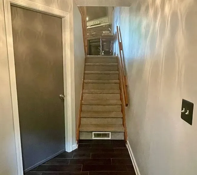Entryway with staircase leading up to the main living area, interior access to the one-car garage, and a small entry closet.