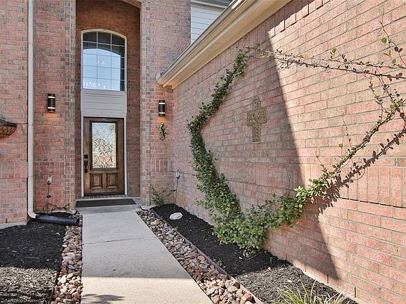 Front walkway and porch. Everything is nicely landscaped, complete with rocks to keep the mulch in place and flower beds defined.