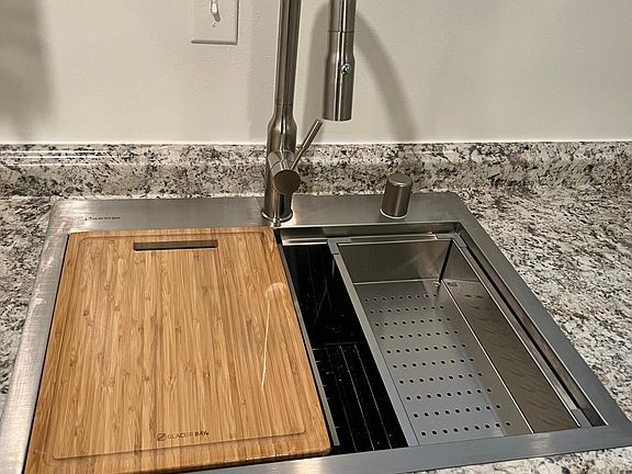 New sink with integrated colander and cutting board.