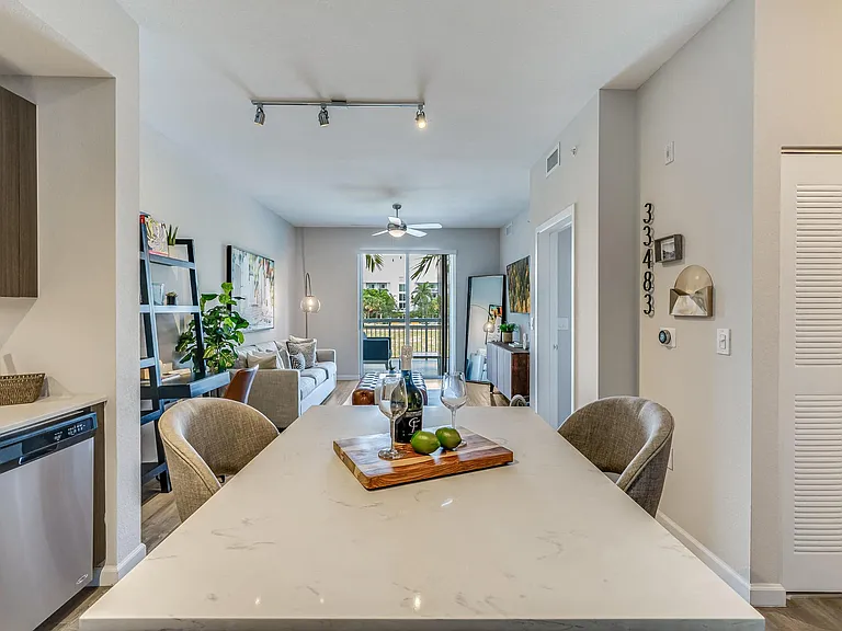 Kitchen Island with Wine Setup and View of Living Room and Balcony