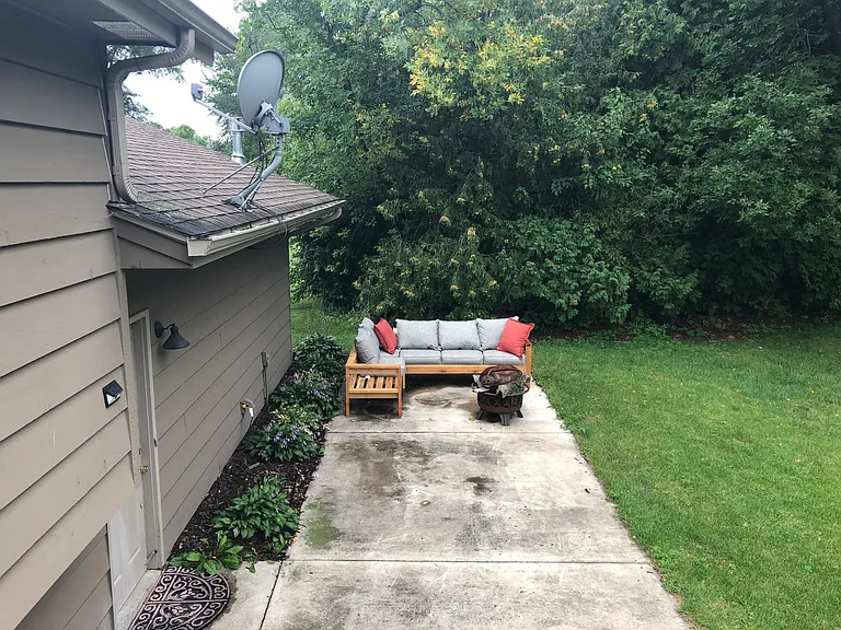 Large back yard patio with vegetative screening on three sides.