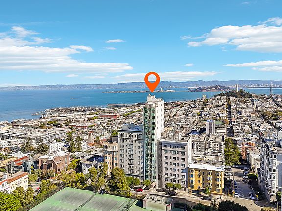 Aerial view of a city with a location marker on top of a tower