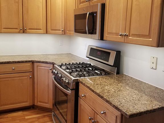 Granite countertop kitchen includes microwave over gas range