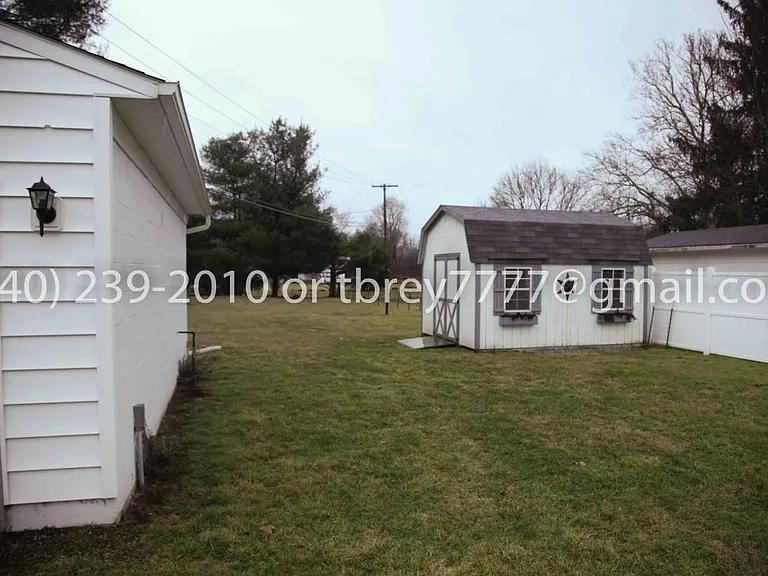 fenced back yard and storage shed