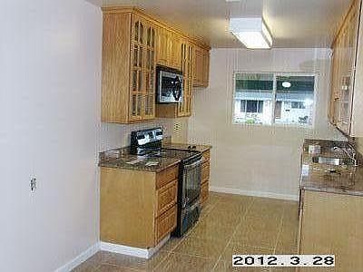 Kitchen with tile floor, granite countertops, wood cabinets