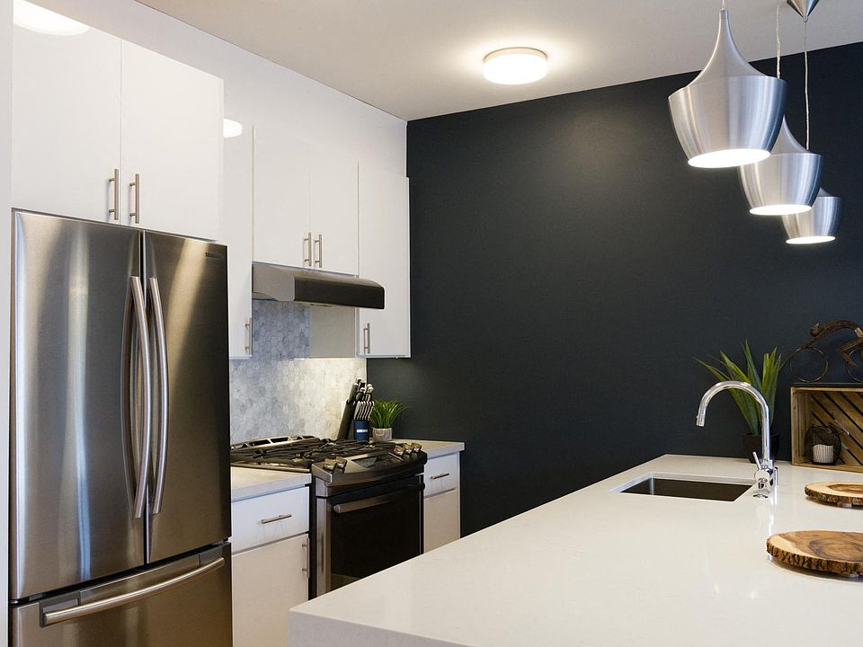 Kitchen with a countertop, refrigerator, sink, and a wooden cutting board