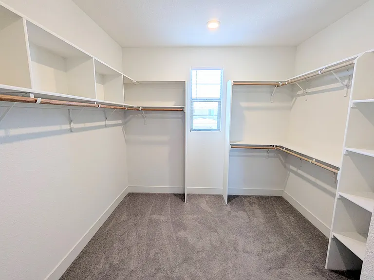 A fashion lover's dream! This massive walk-in closet offers extensive custom shelving and abundant hanging space, providing the ultimate organization solution for your entire wardrobe in this grand master suite.