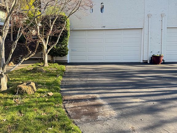 View from street - condo on top and garage underneath with long driveway for parking