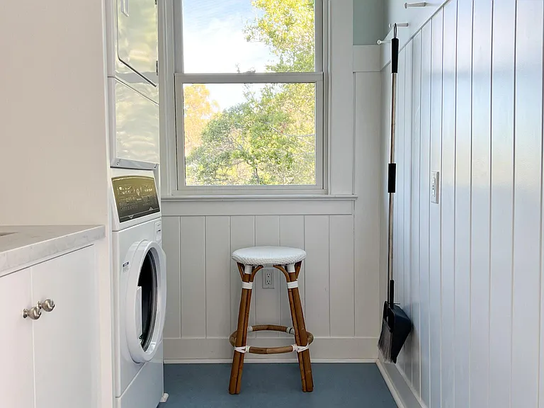 Laundry Room. Stacked Speed Queen Washer and Dryer, large stainless steel utility sink, storage shelves and peg wall finish out this space off of the kitchen.