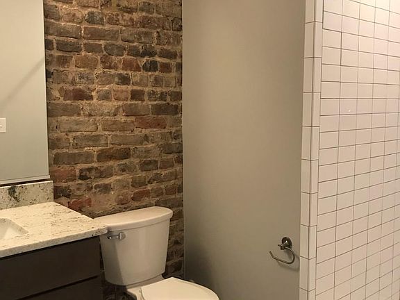Stand up shower exposed brick bathroom