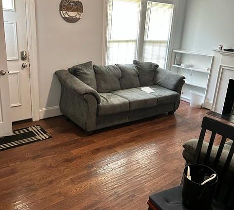 Hardwood floors, open shelving in current grey painted room with grey couches. Great natural light.