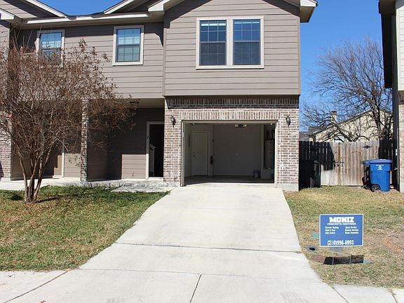 Front of duplex with garage door open