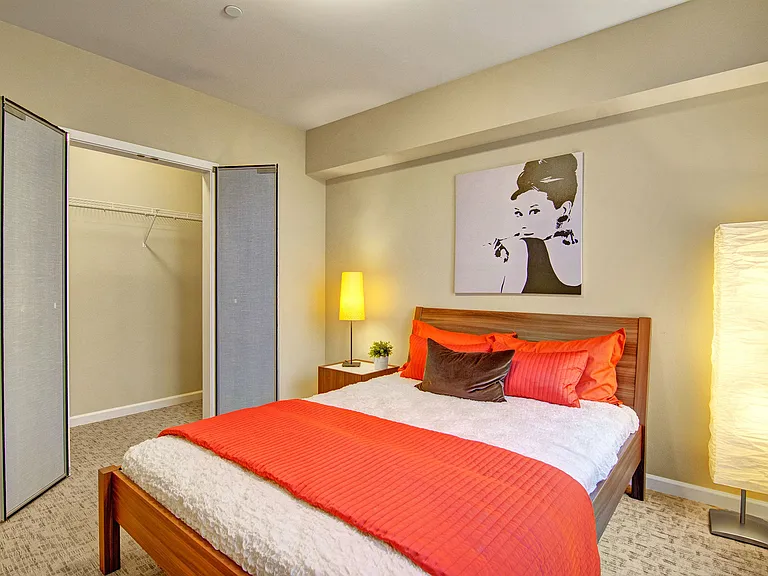 A bedroom with a large closet with shelving for additional storage