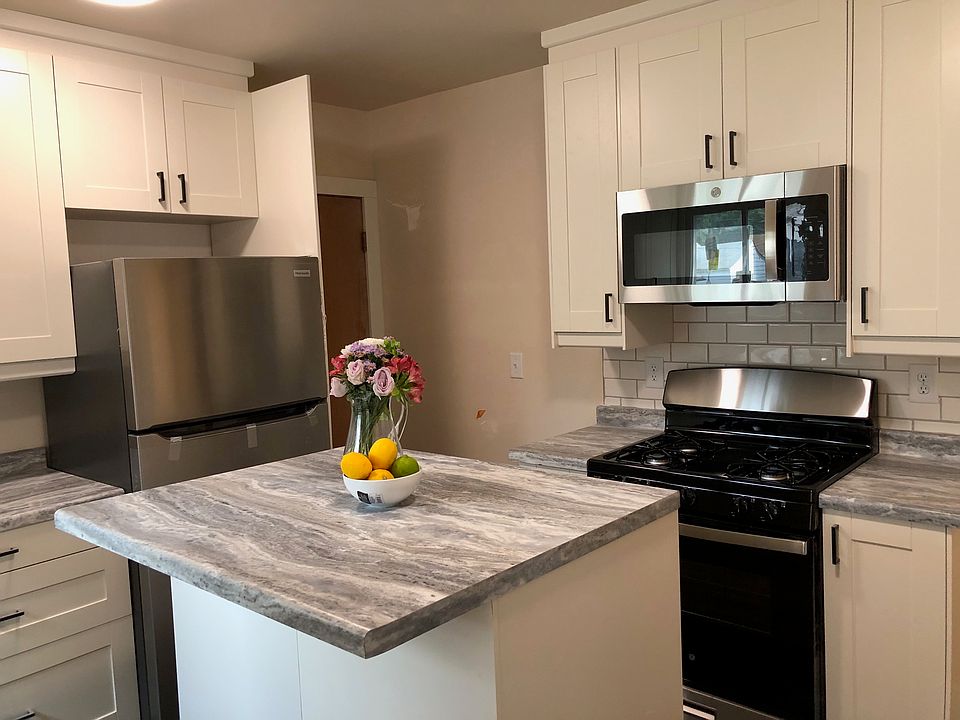 Kitchen with new appliances and tile backsplash, looking towards back door (basement access)
