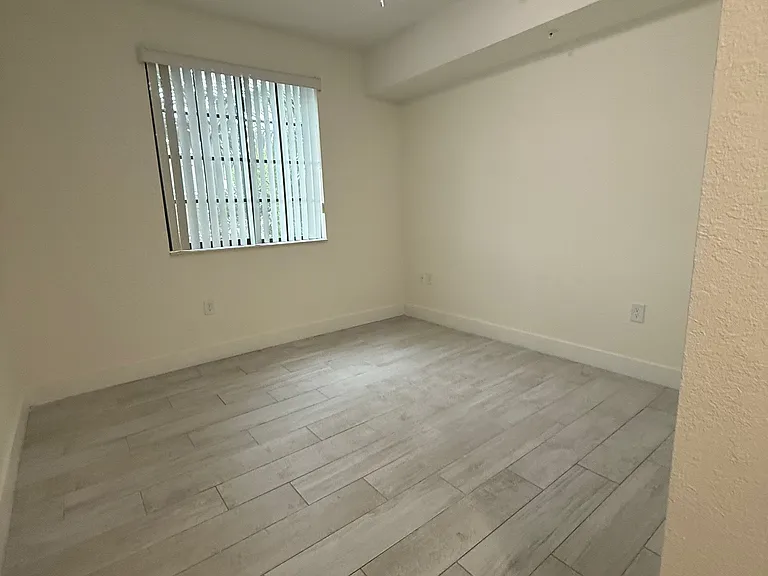 Spacious and modern tile flooring room with large window for natural light.