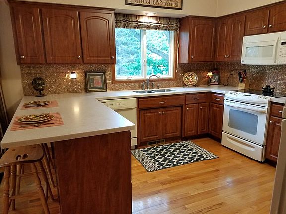 The kitchen is complete with Cherry Wood cabinets, hardwood floors, new windows throughout (ANDERSON) and an open, spacious feel.