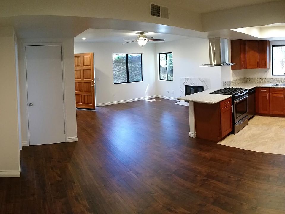 ground level living room, marble fireplace, ceiling fan, newly redone kitchen with granite countertops, dining area, main floor bedroom, laundry room, bathroom with shower and attached garage for storage.