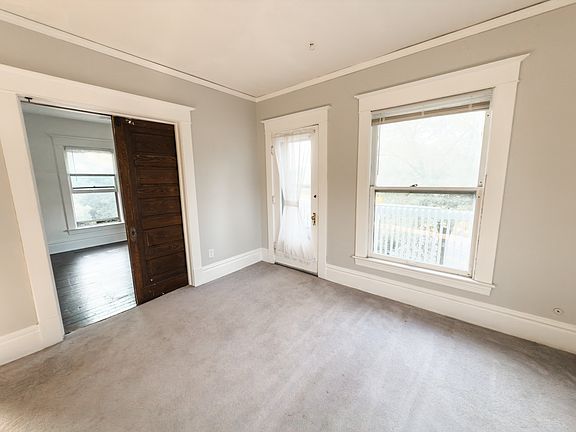 A large wooden pocket door leads to one of the bedrooms.