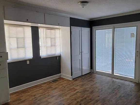 Large Bedroom with built-in dresser cabinets for storage, two closets and sliding doors to the patio.