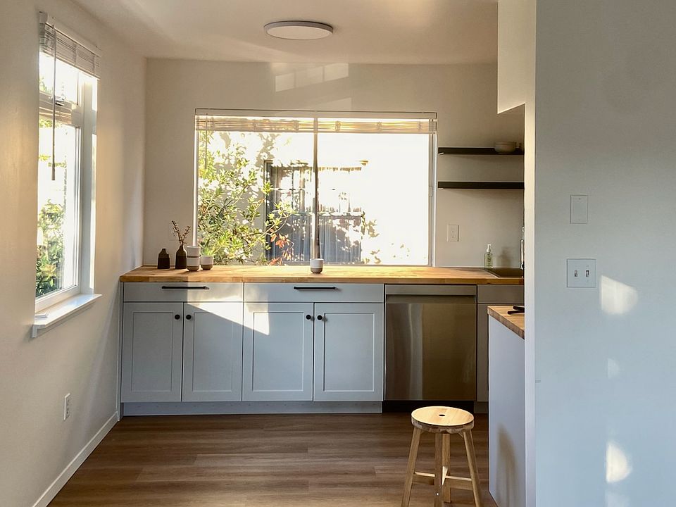 New kitchen cabinets with stainless steel appliances and butcher block countertops.