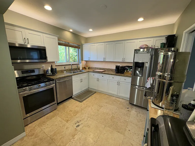 Spacious kitchen area With hardwood cabinetry and lighting