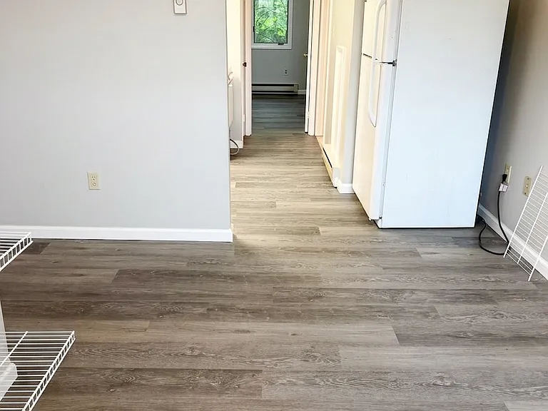 Another angle of the main living space showcasing the open layout, freshly painted interior, and the seamless flow of the new LVP flooring.