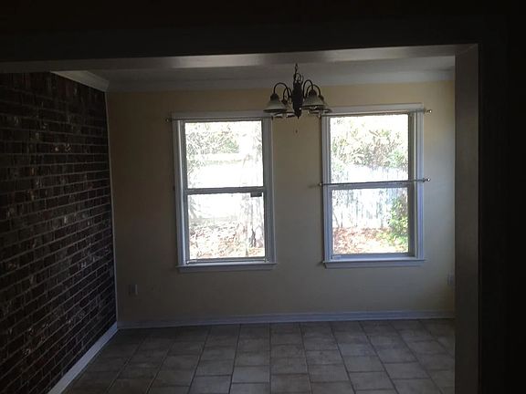 View to dining room from kitchen dining area. This room could be used for an office or other space with multiple windows and natural light. exits to courtyard.
