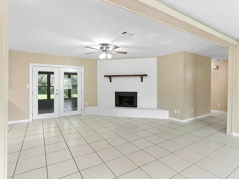 Living room looking into patio door and bedroom hallway