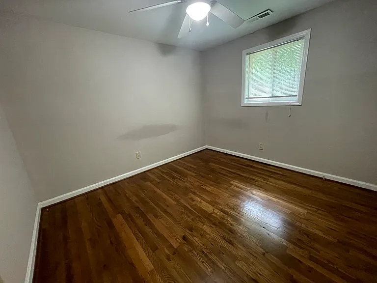 Bedroom 2 includes hardwood flooring and ceiling fan. Window blinds throughout are also included