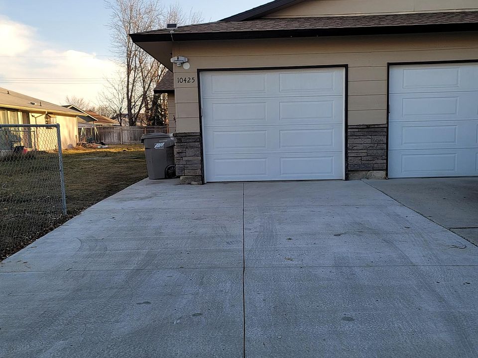 Driveway with new concrete and garage with new remote door. New wooden fence under current construction.